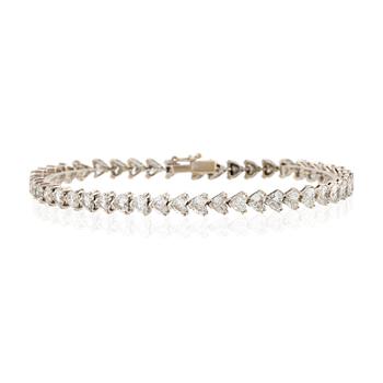 512. An 18K white gold bracelet set  with heart-shaped brilliant-cut diamonds.