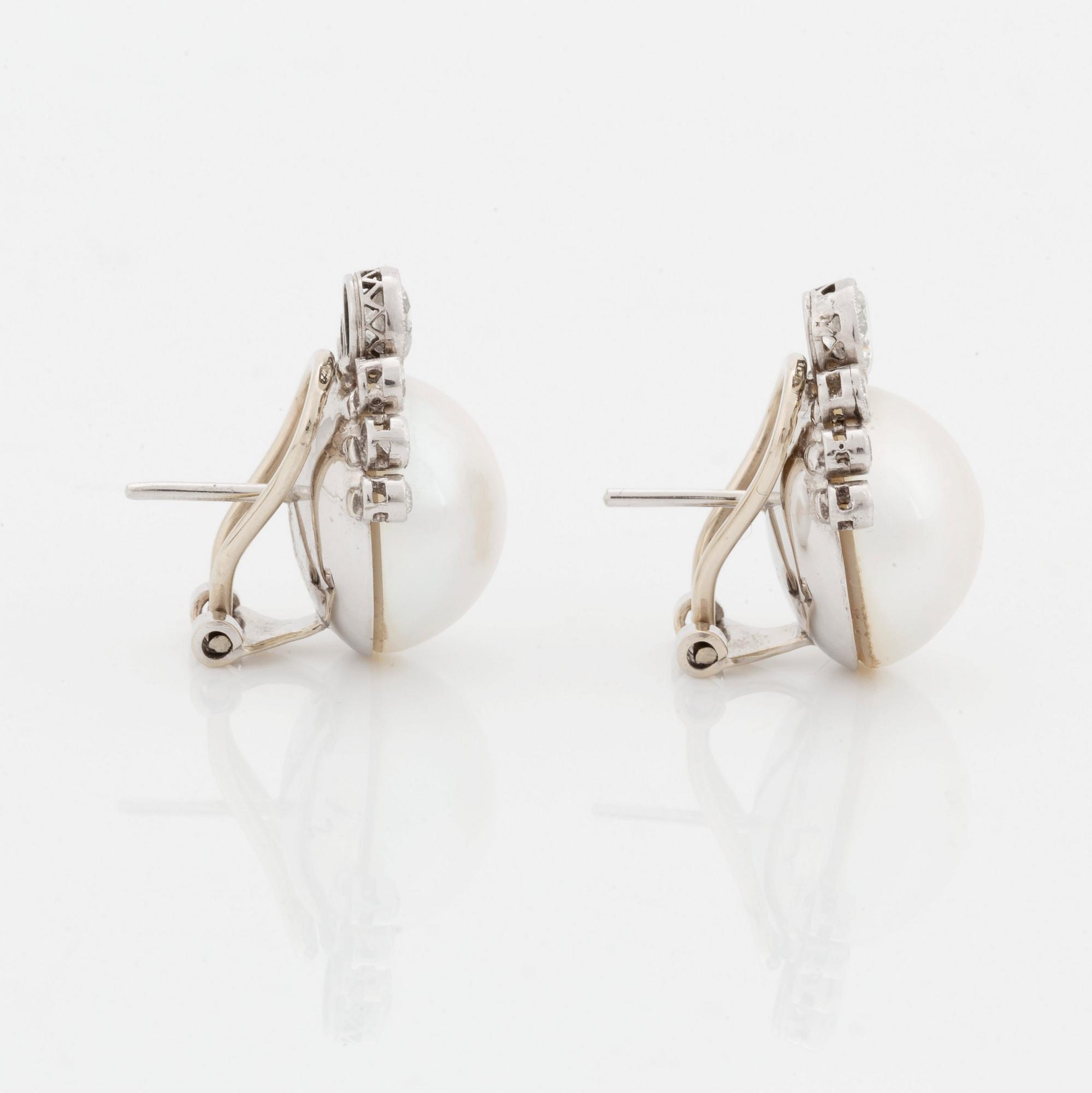 A pair of 18K white gold earrings set with mabe pearls and round brilliant-cut diamonds.