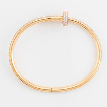 A Cartier "Juste un Clou" bracelet in 18K gold set with round brilliant-cut diamonds.