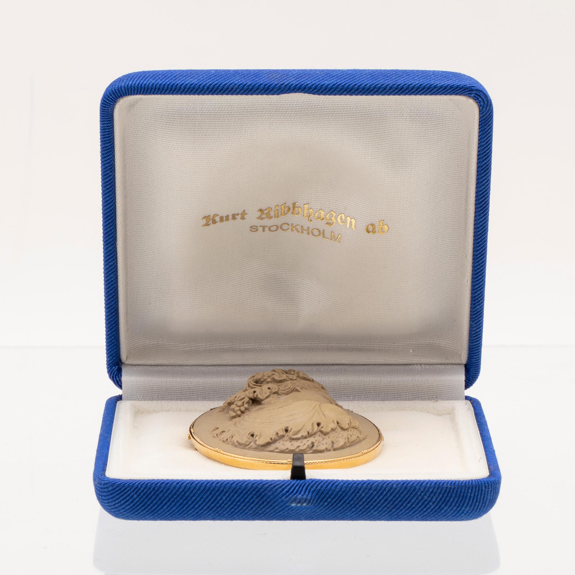 Brosch med lavakamé infattad i 18K guld.