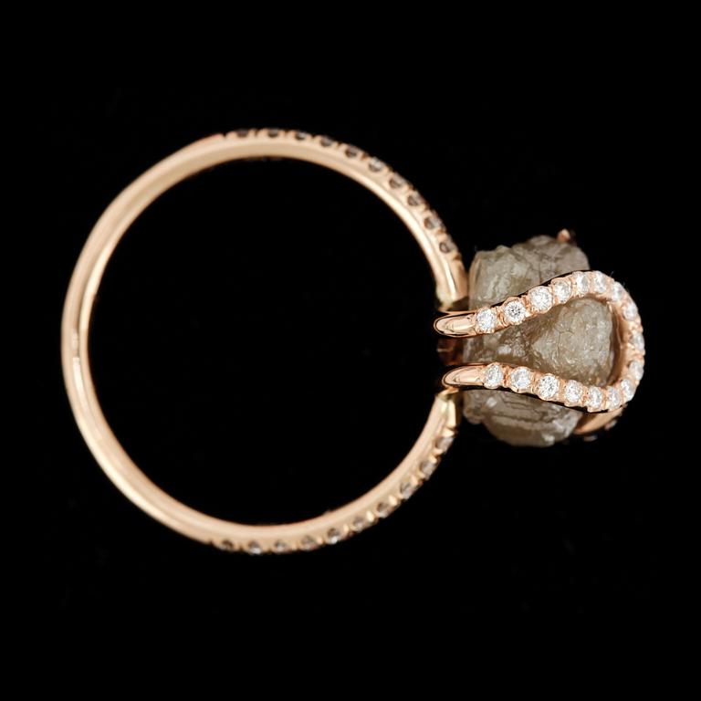 RING, roséguld 18k, "diamond in the rough" med grå rådiamant samt små briljantslipade diamanter. Vikt ca 3 gram.
