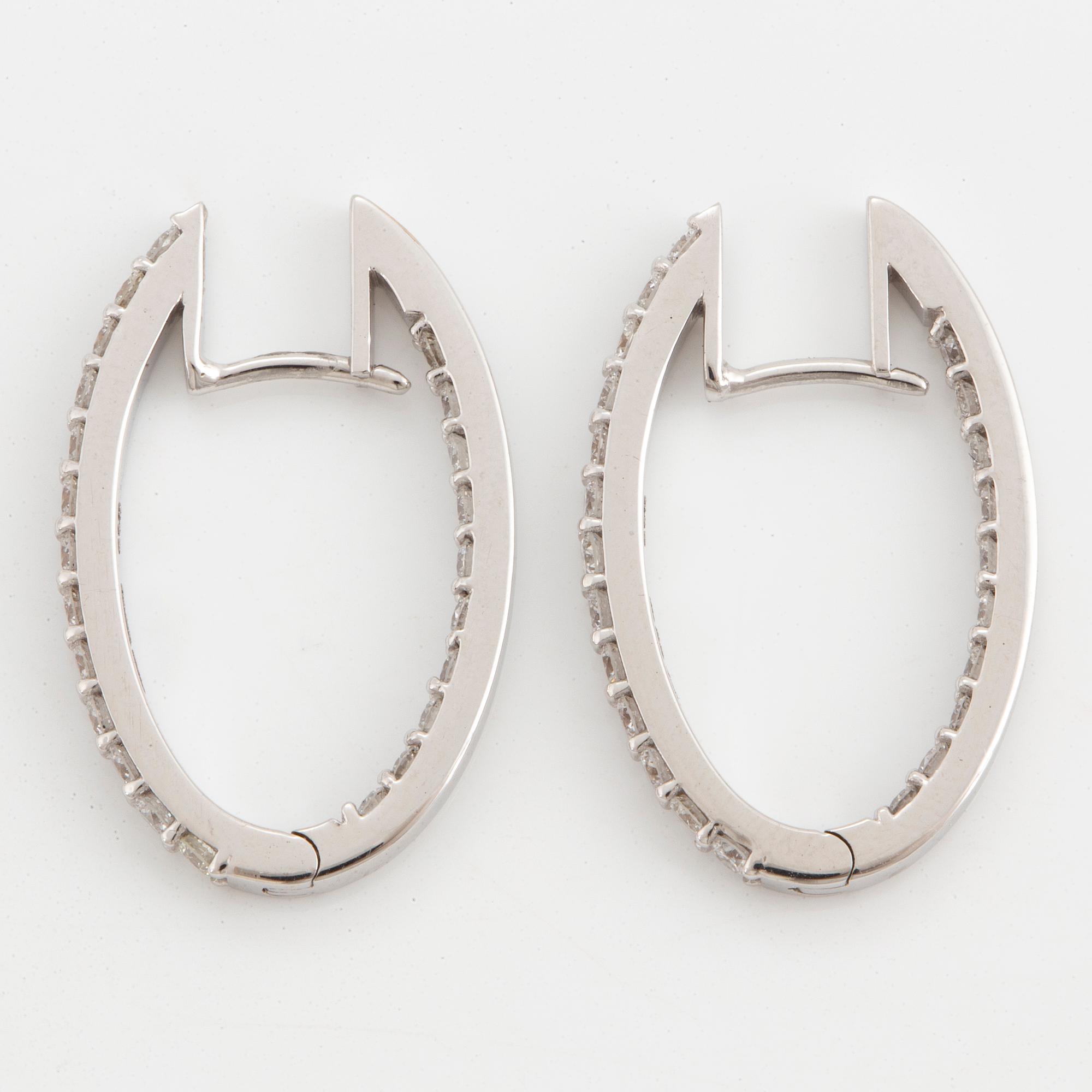 A pair of 18K gold earrings set with brilliant-cut diamonds.