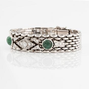 An 18K gold bracelet  with cabochon-cut emeralds and round brilliant- and eight-cut diamonds.
