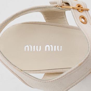 MIU MIU, a pair of creme white canvas sandals.