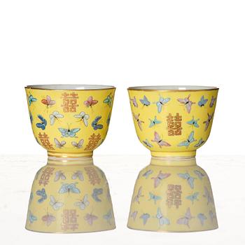 A pair of yellow glazed double happiness cups with butterflies, Qing dynasty, with Tongzhis four character mark to base.