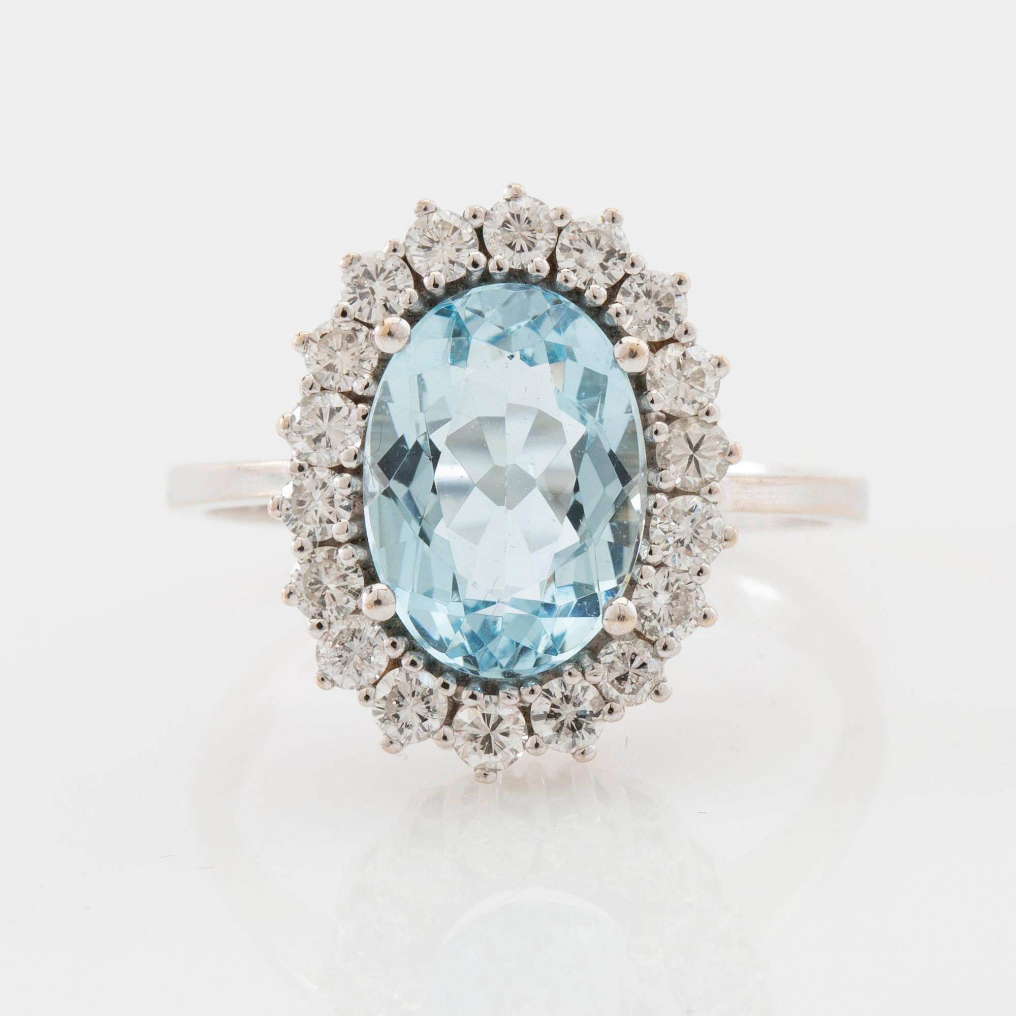 Ring 18K white gold set with an oval faceted aquamarine and round brilliant-cut diamonds.