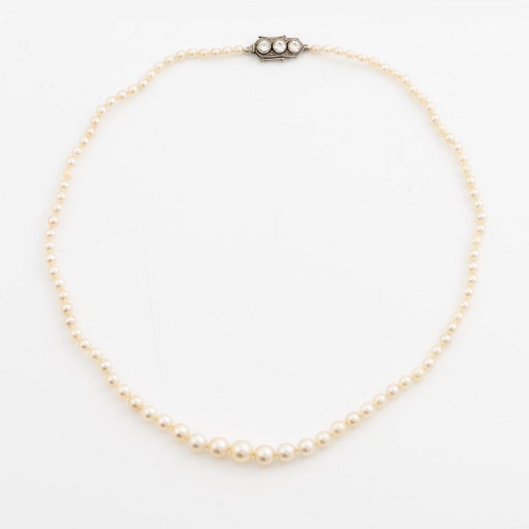 Collier med doserade pärlor, lås vitguld med tre gammalslipade diamanter.