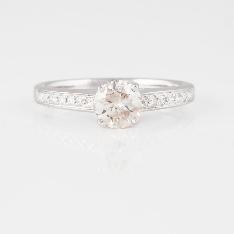 RING, 18K vitguld med briljantslipad diamant ca 0.70 ct samt små briljantslipade diamanter ca 0.10 ct. Vikt 2,9 gram.