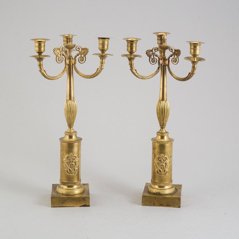 A pair of early 19th century brass candelabra for three candles.