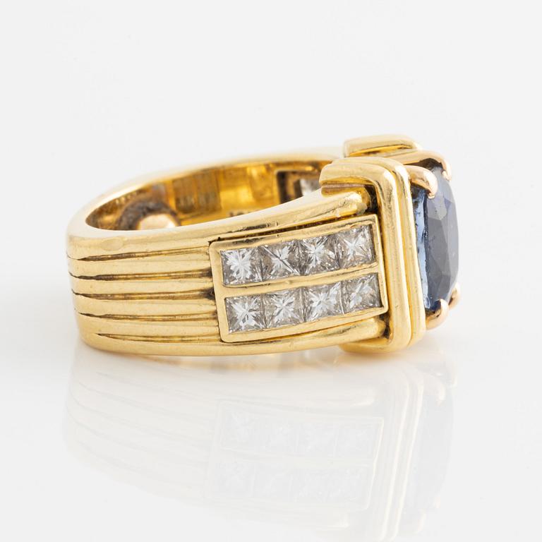 Ring in 18K gold set with an oval faceted sapphire and princess-cut diamonds.