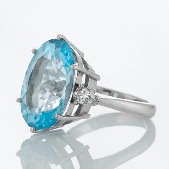 An 18K white gold ring set with a faceted topaz and two pear shaped brilliant-cut diamonds.