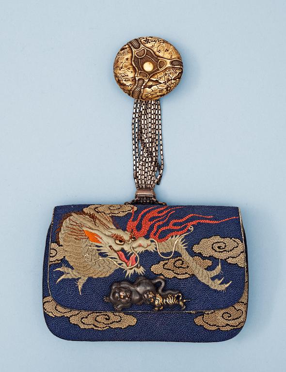 A Japanese embroided tabakoire with a kanamono in the shape of two tigers, a metal chain that holds a carved ivory manjû, second half of 19th Century. Signed.