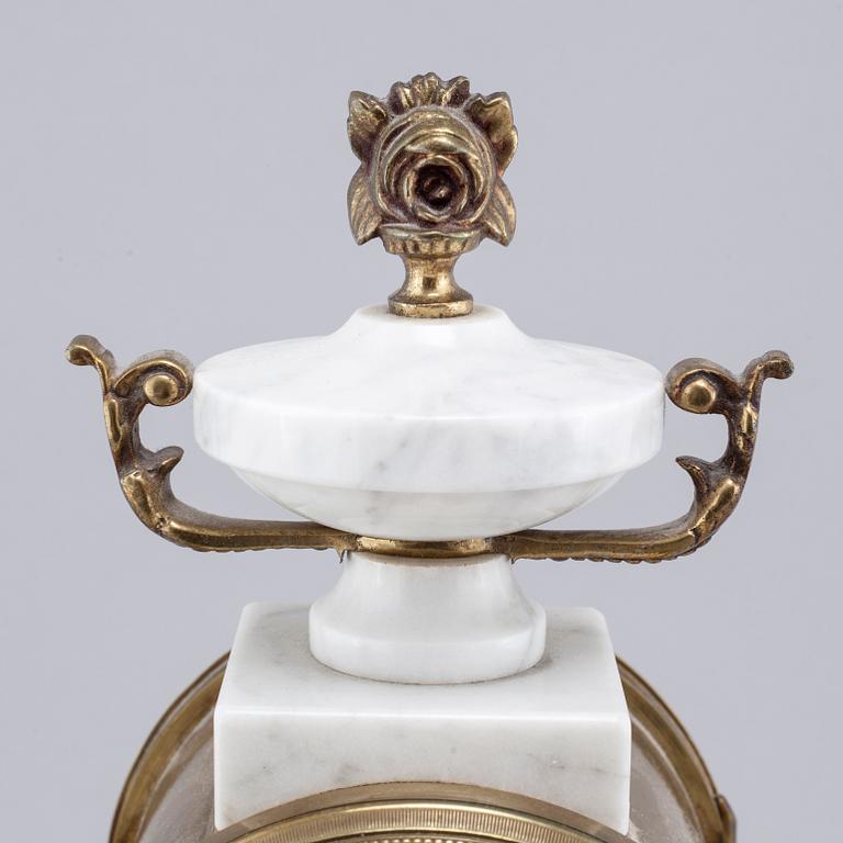 A French mantlepiece clock and a pair of candelabras, first half of the 20th century.