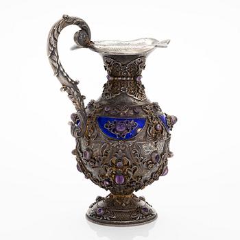 A parcel-gilt silver jug with enamel, and cabochon cut amethysts. First half of the 20th century.
