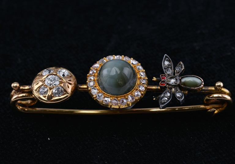 A BROOCH,  a chrysoberyl cat´s eye. Old- and rose cut diamonds c. 0.65 ct. 18K gold. Weight 8,4 g.