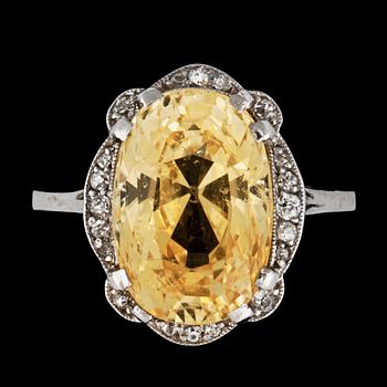 A ring with a yellow sapphire circa 9.40 cts surrounded by old-cut diamonds.