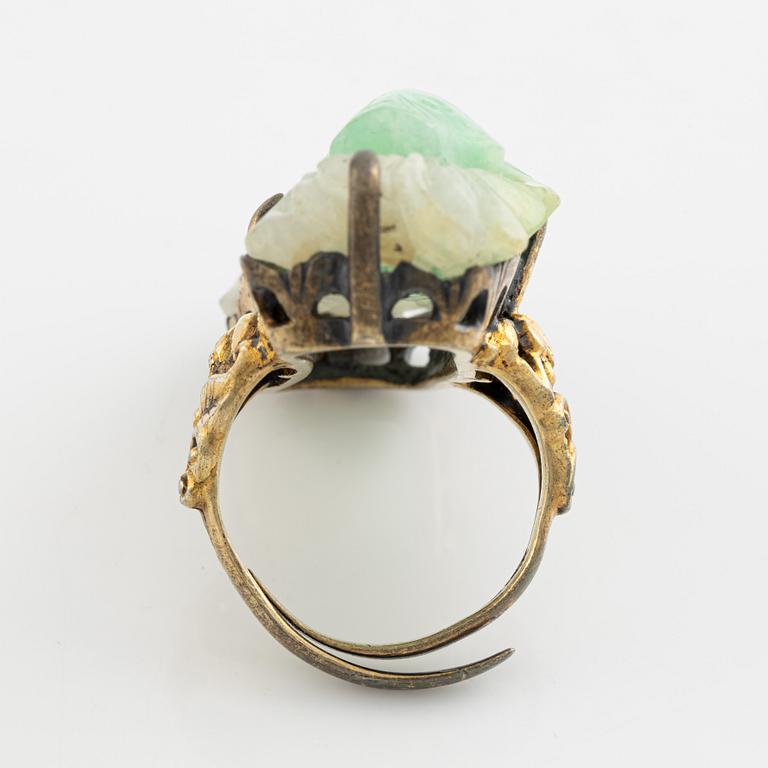 Ring in yellow metal with a white/green stone, possibly nephrite.".