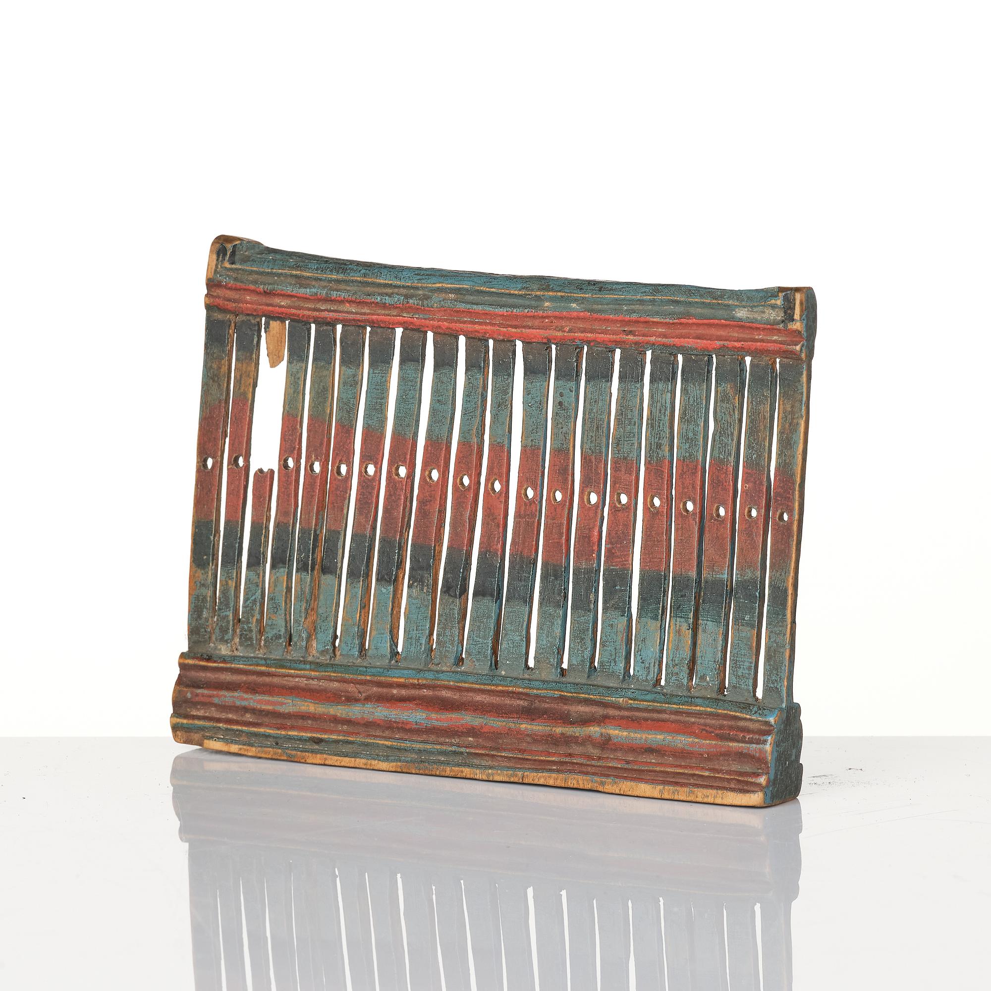 A Swedish carved and polychrome painted weaving tool from Hälsingland, 19th century.