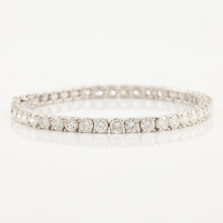 An 18K white gold tennis bracelet set with round brilliant-cut diamonds.