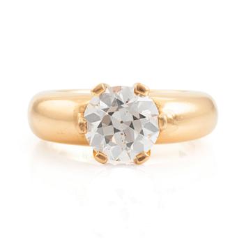 An 18K gold ring set with a round brilliant-cut diamond.