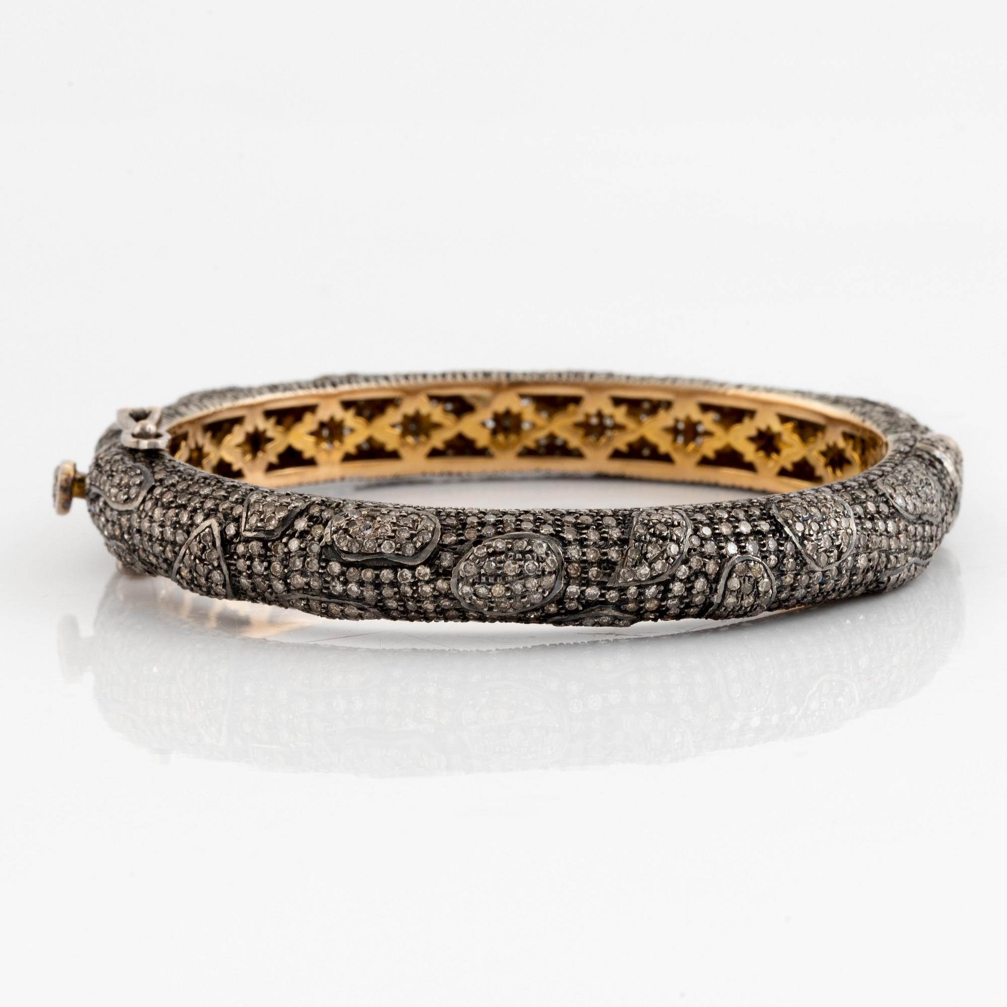 Silver and giltet gold and eight cut diamond bangle.
