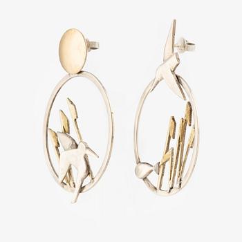 A pair of earrings featuring birds and fish, silver with gold detail.