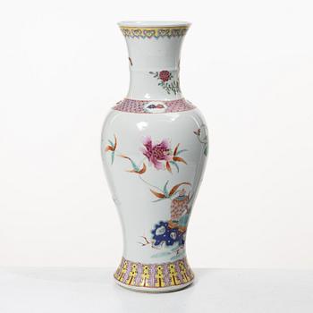 A slender famille rose 'flowers and antiques' vase, late Qing dynasty/early 20th century.