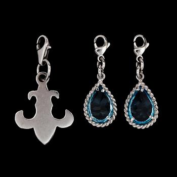 283. Two white gold and blue topas charms.