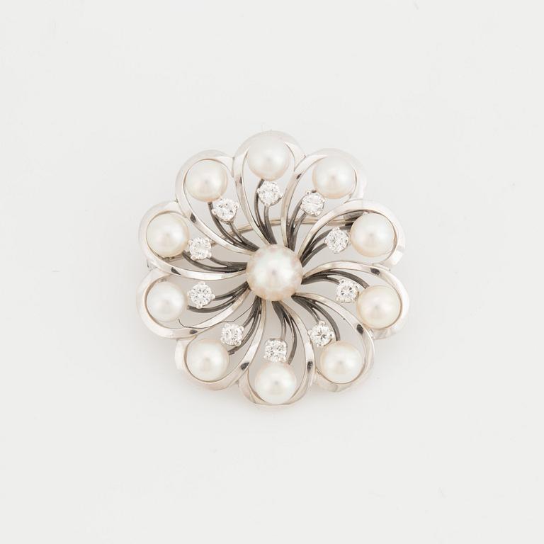 A brooch set with cultured pearls and round, brilliant-cut diamonds.