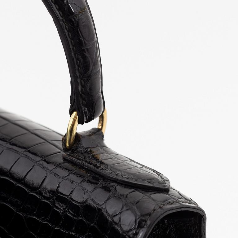 1962 black alligator 'Kelly' handbag by Hermès.