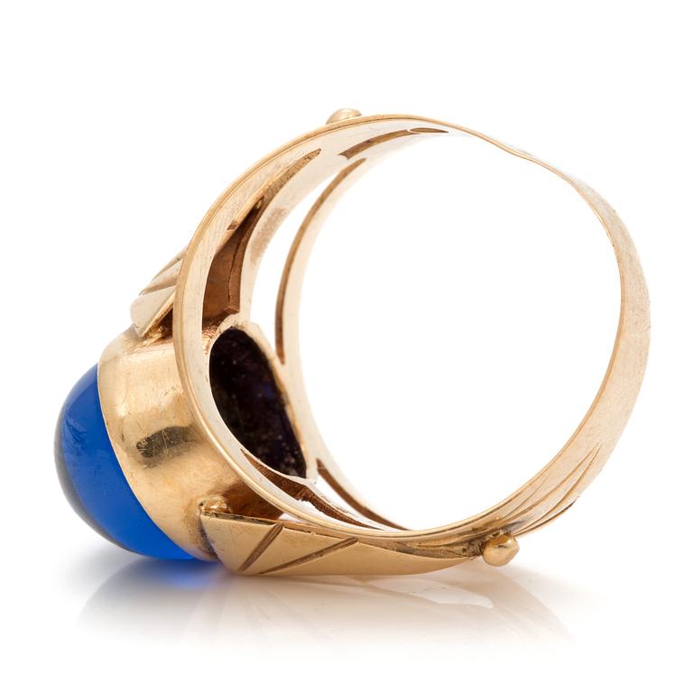 A ring set with an oval, cabochon-cut, synthetic, blue spinel.