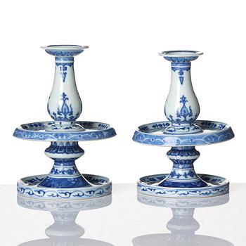 A pair of blue and white pricket candle sticks, with a poem, Qing dynasty with a Qianlong mark and of the period.