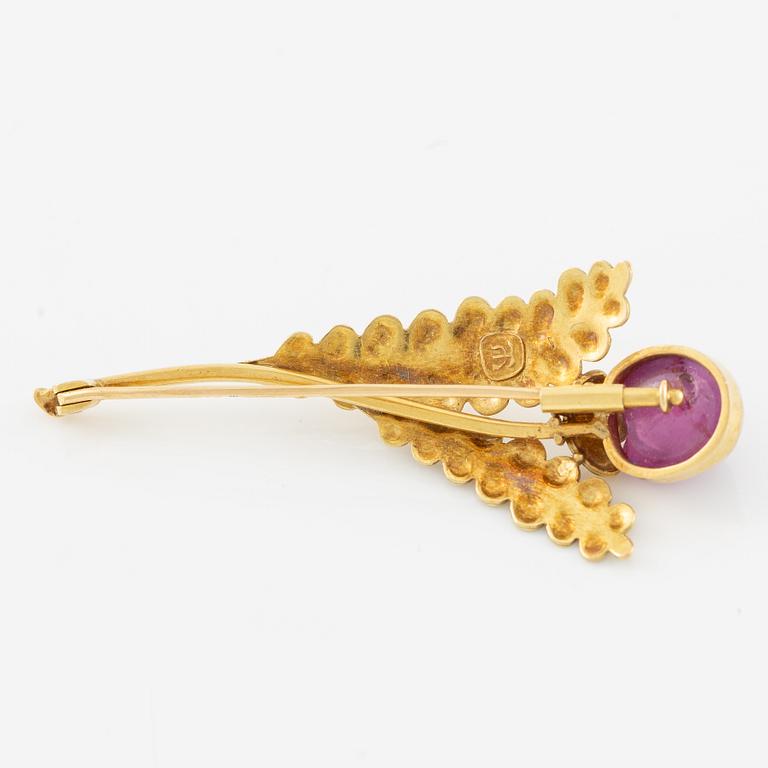 Brooch, 18K gold with cabochon-cut ruby, decoration of leaves.
