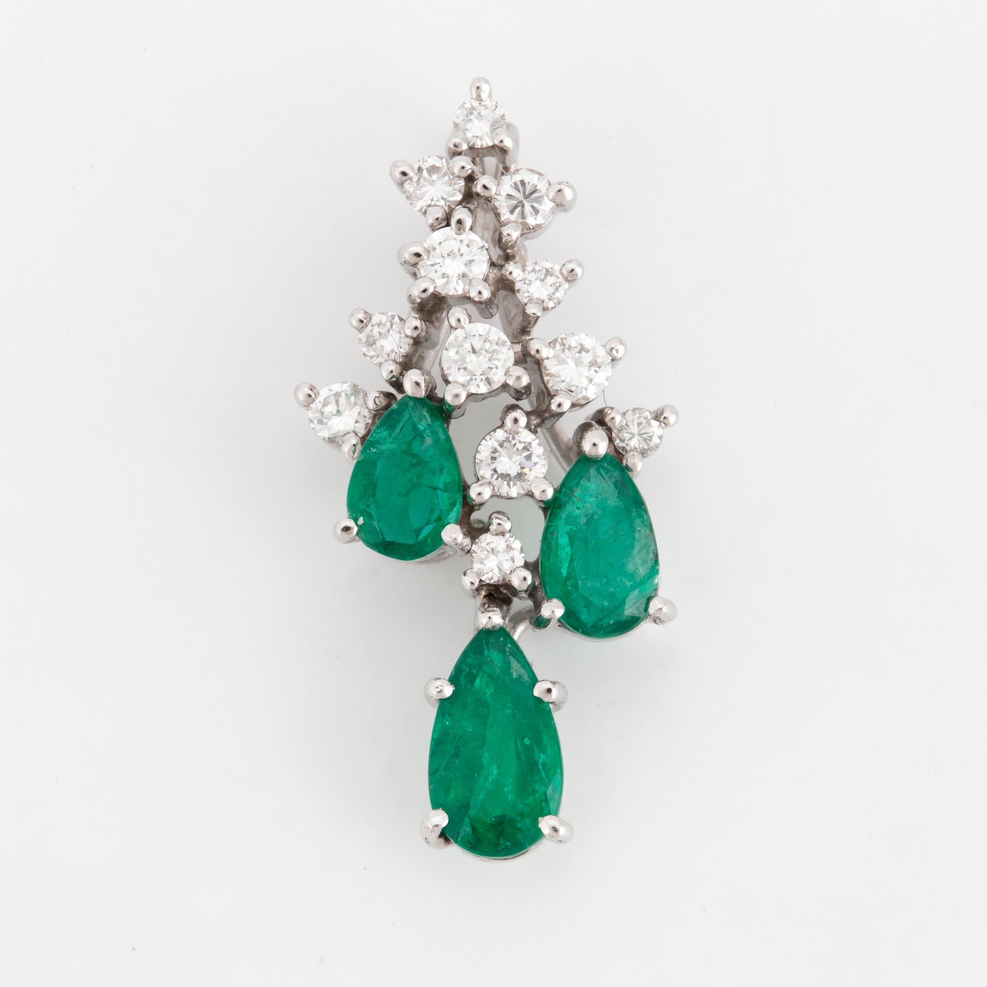 An 18K white gold emerald and diamond pendant.