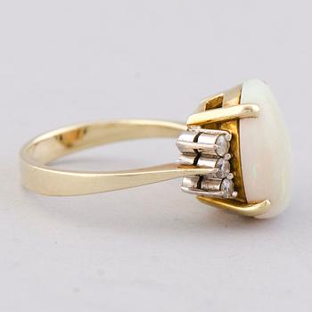 A RING, cabochon cut opal, brilliant cut diamonds, 14K gold.