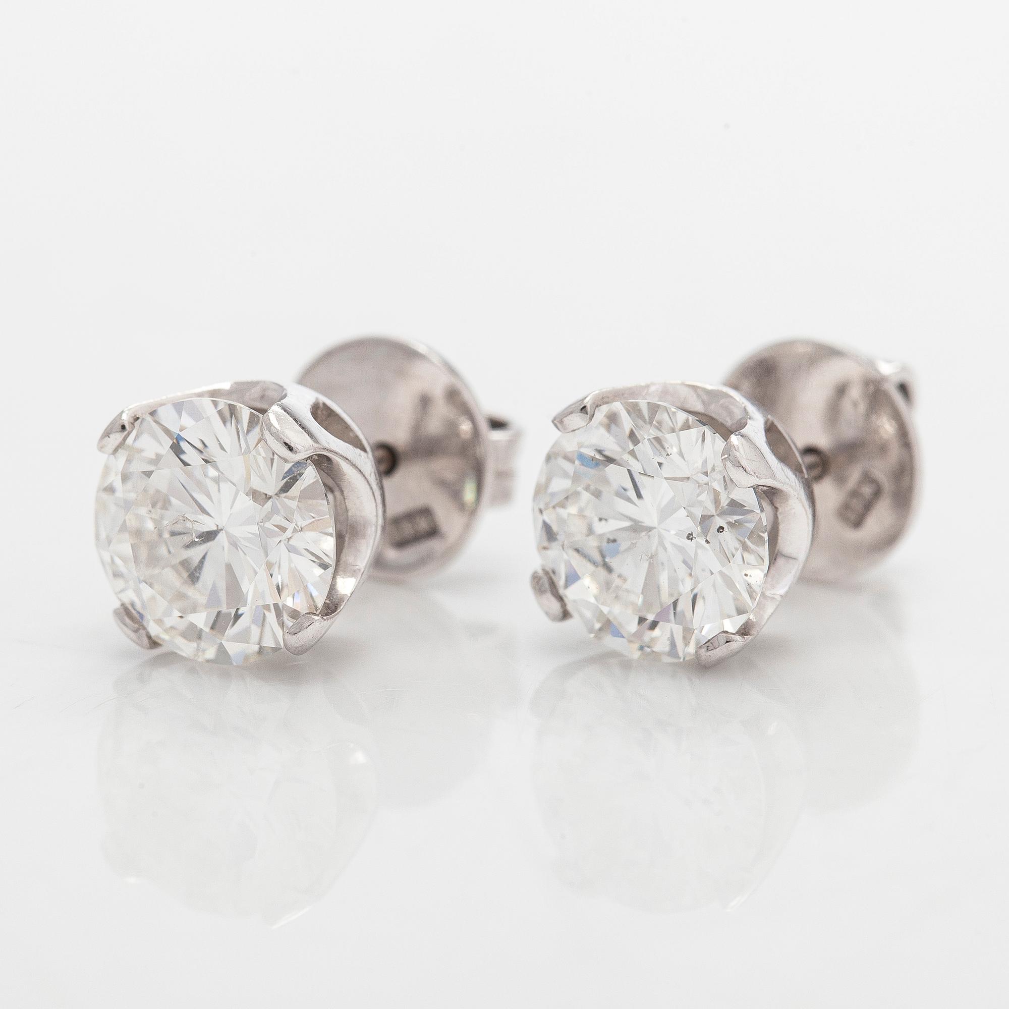 A pair of brilliant-cut diamond stud earrings in 18K white gold.