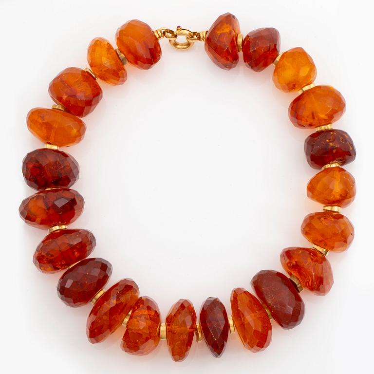 An amber necklace comprising graduated faceted amber beads ca 40 - 50 mm.