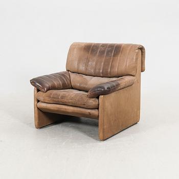 A set of two leather armchairs and a stool by De Sede, Schweiz second half of the 20th century.