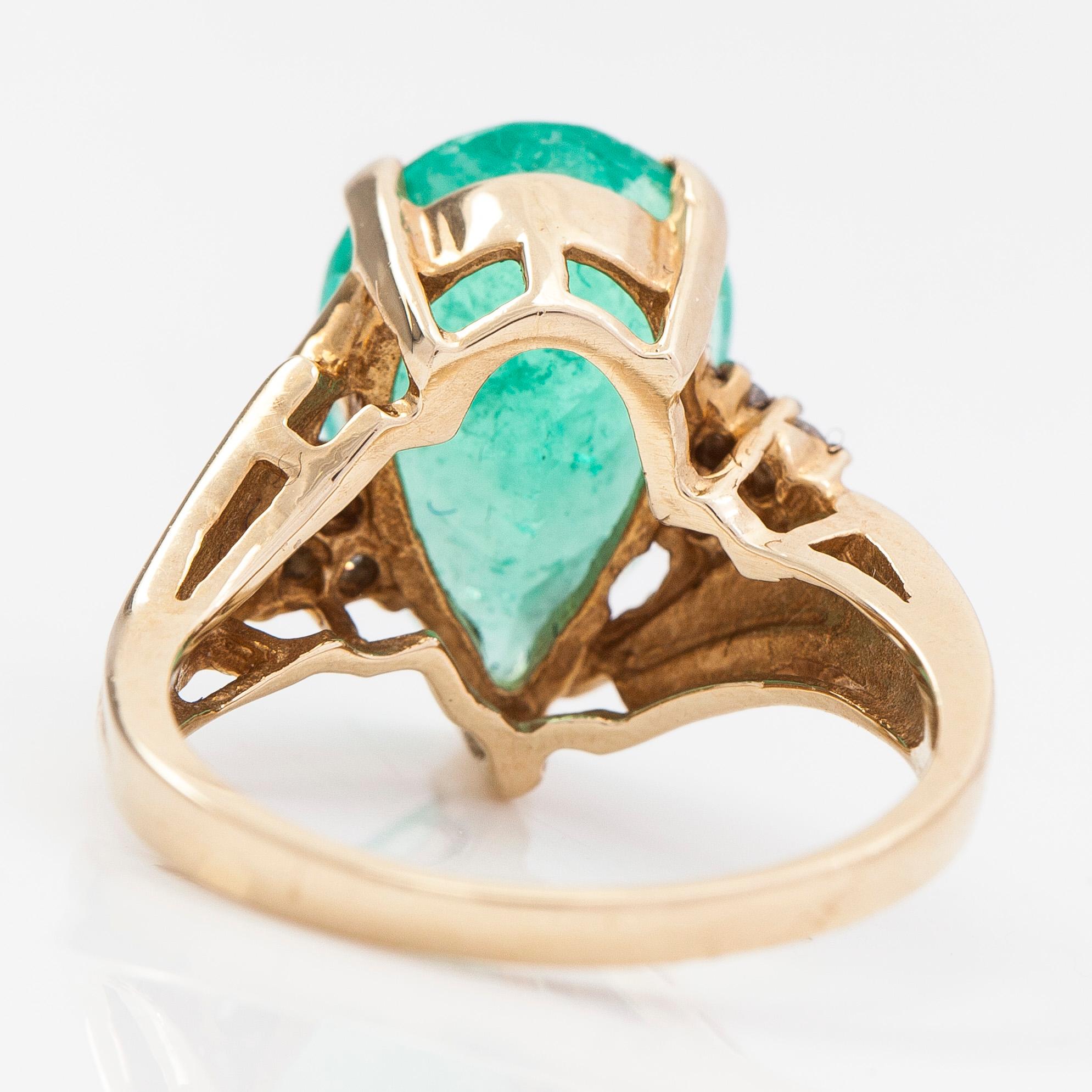 Ring, ca 10-11K gold with a pear shaped emerald and diamonds approx 0.10 ct in total.