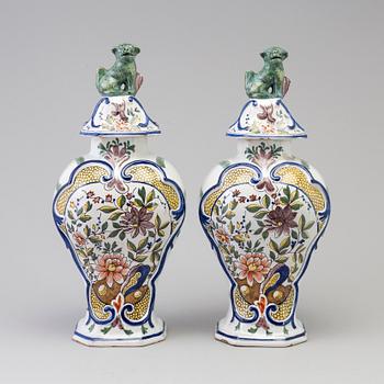 A pair of faience lidded urns, 18th/19th century.