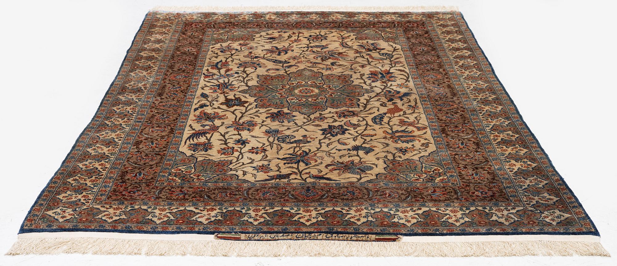 A semi-antique silk Isfahan rug, Central Persia, signed (Sadegh) Seirafian, c. 209 x 142 cm.