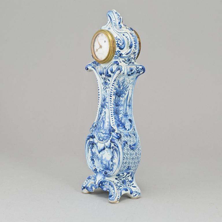 An 18th Century table clock, by Jacob Koch (1737-1805), Stockholm. Case in rococo-style, faience, marked AK.