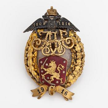 A gold plated silver commemorative badge with enamel decor. Finska guldsmeds AB, Finland/Russia 1916.