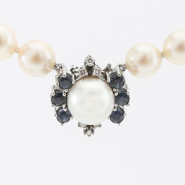 Necklace of cultured pearls with an 18K white gold clasp and round single-cut diamonds and round faceted sapphires.