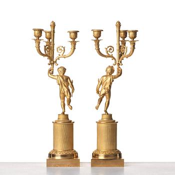 A pair of French Empire early 19th century three--light candelabra.