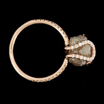 RING, roséguld 18k, "diamond in the rough" med grå rådiamant samt små briljantslipade diamanter. Vikt ca 3 gram.