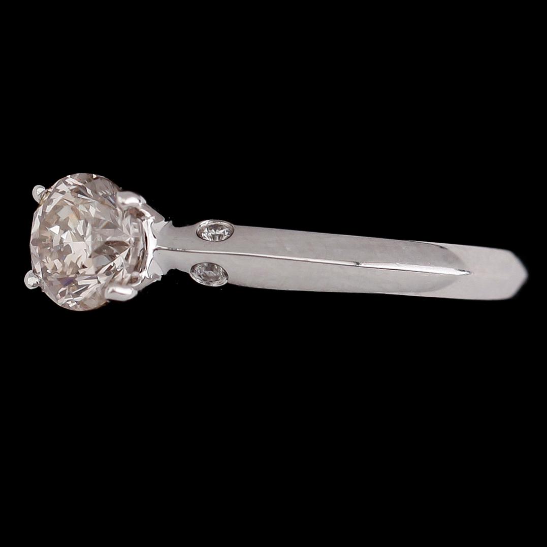 RING, 18 k vitguld, solitär briljantslipad diamant ca 0.71 ct, 4 mindre briljantslipade diamanter tot ca 0.03 ct.