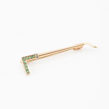 Brooch in the shape of a riding crop, 8K gold with faceted emeralds and rose-cut diamonds.