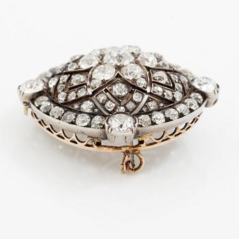 A brooch/pendant in gold and platinum with old-cut diamonds.