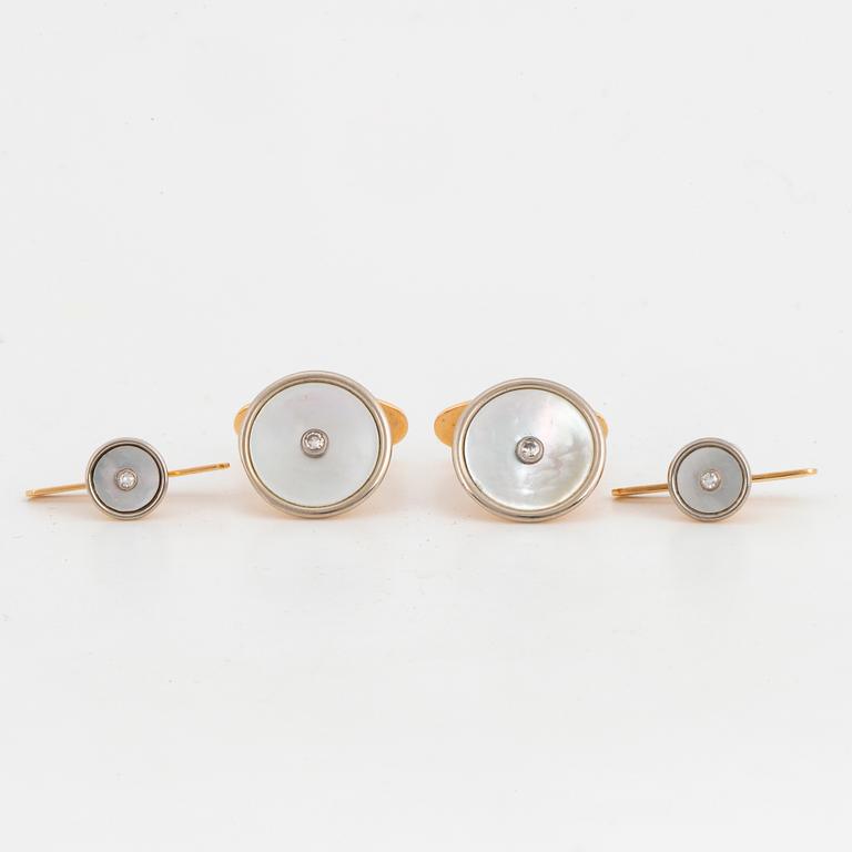 A pair of cufflinks and a pair of shirt buttons.